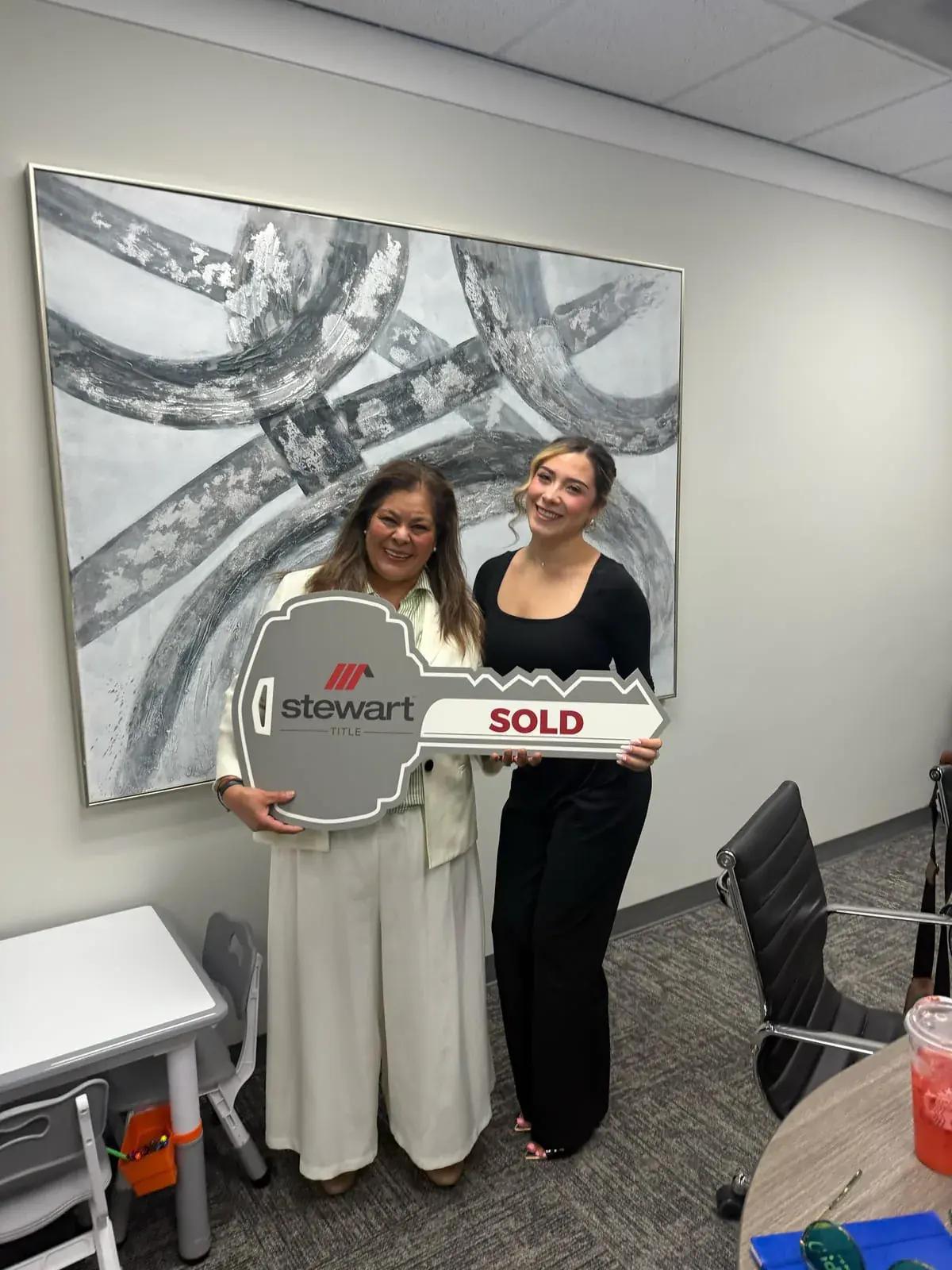 Ximena Martinez and a client holding a giant SOLD key on closing day
